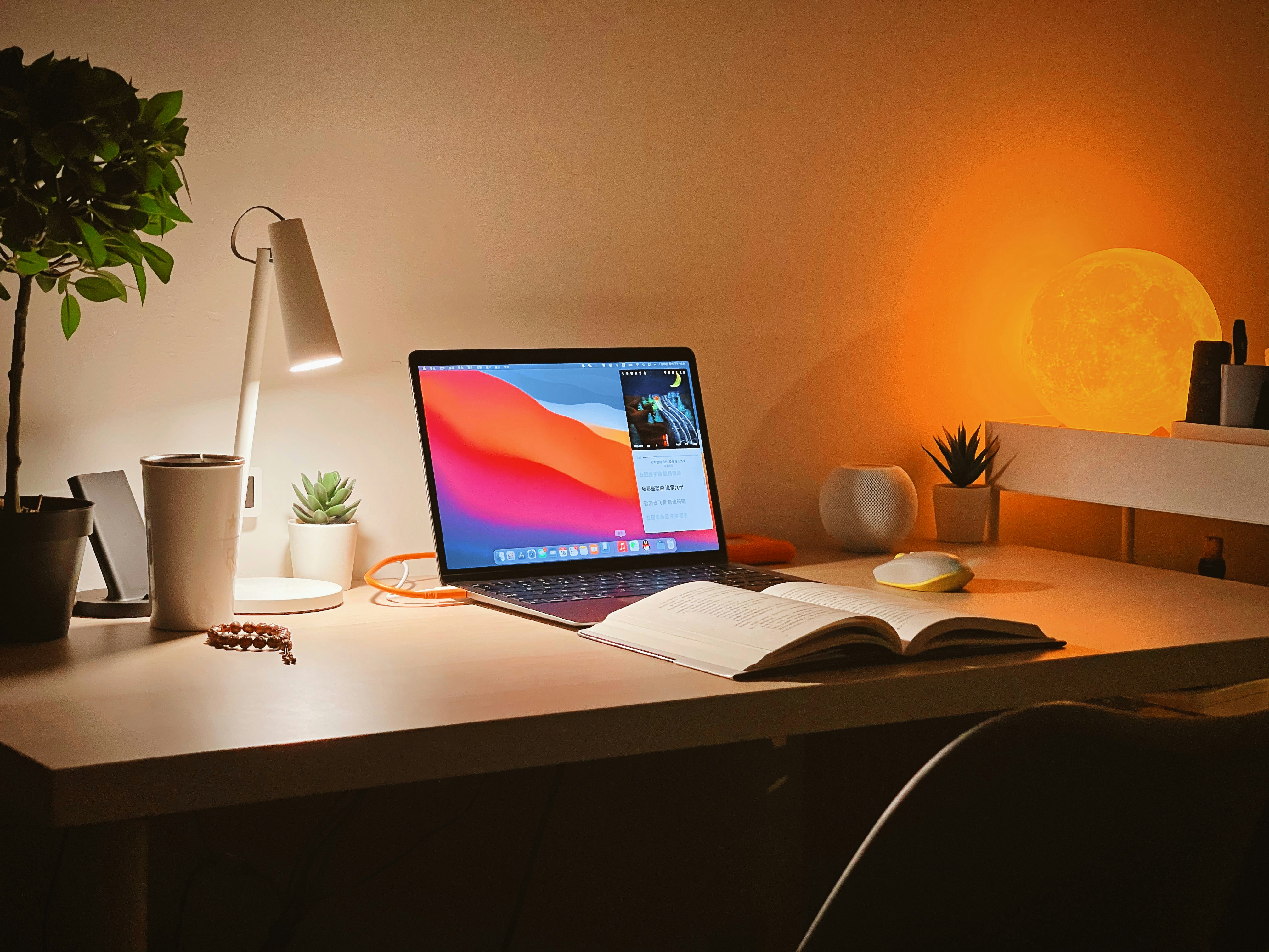Lernplatz mit MacBook und offenem Buch